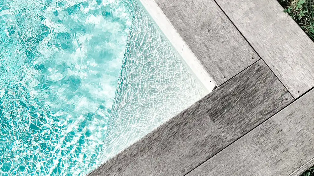 Coping meeting the decking at the edge of a finished pool