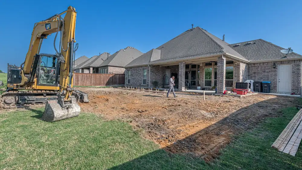 An excavator digging out a backyard at a Texas home