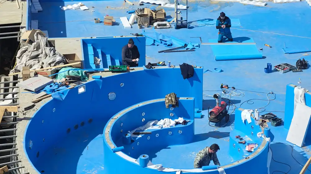 Crews working inside a pool shell under construction