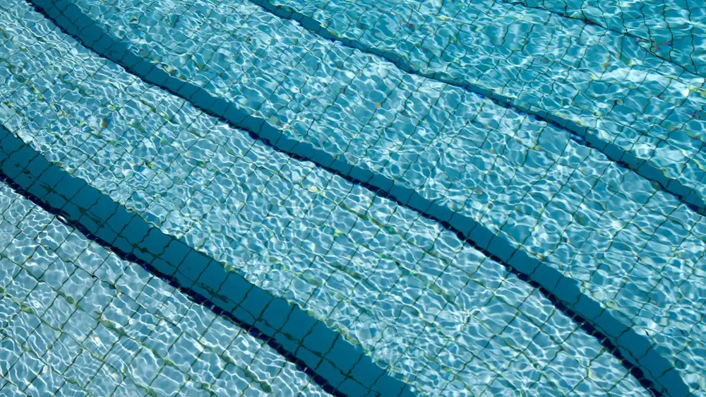 Clear water standing over the tiled steps of a newly filled pool