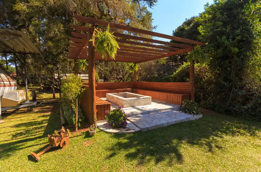 Wooden gazebo in a garden with stone flooring