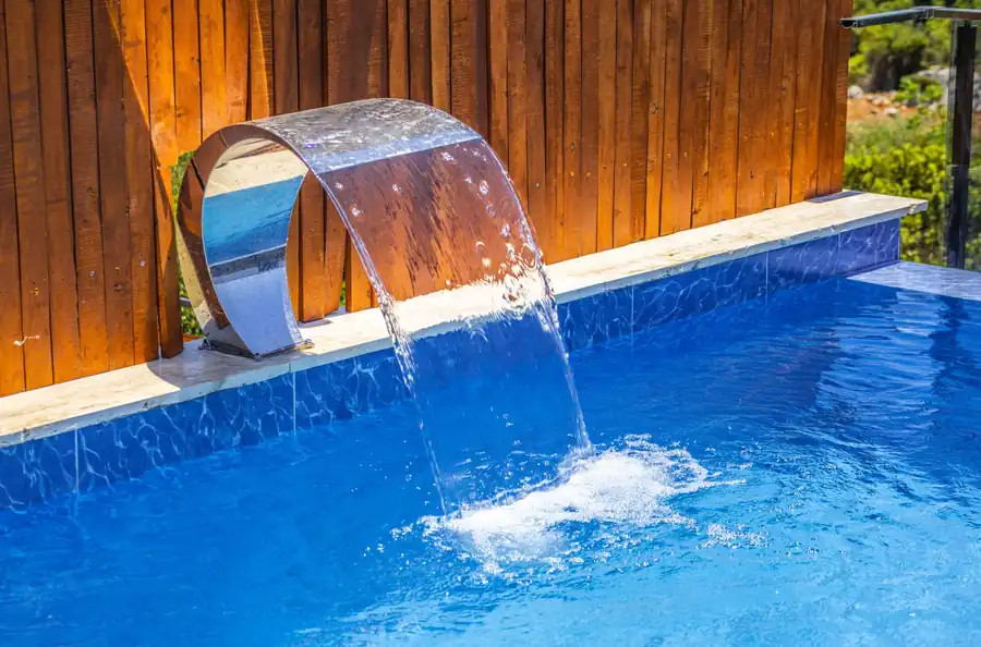 Stainless steel sheer descent pouring into a blue pool