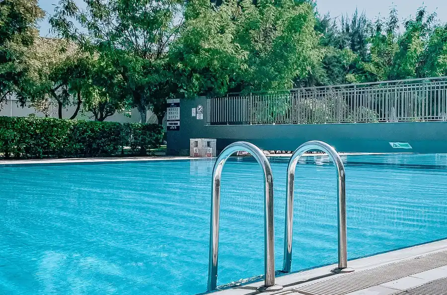 Crystal-clear pool surrounded by greenery on a bright day