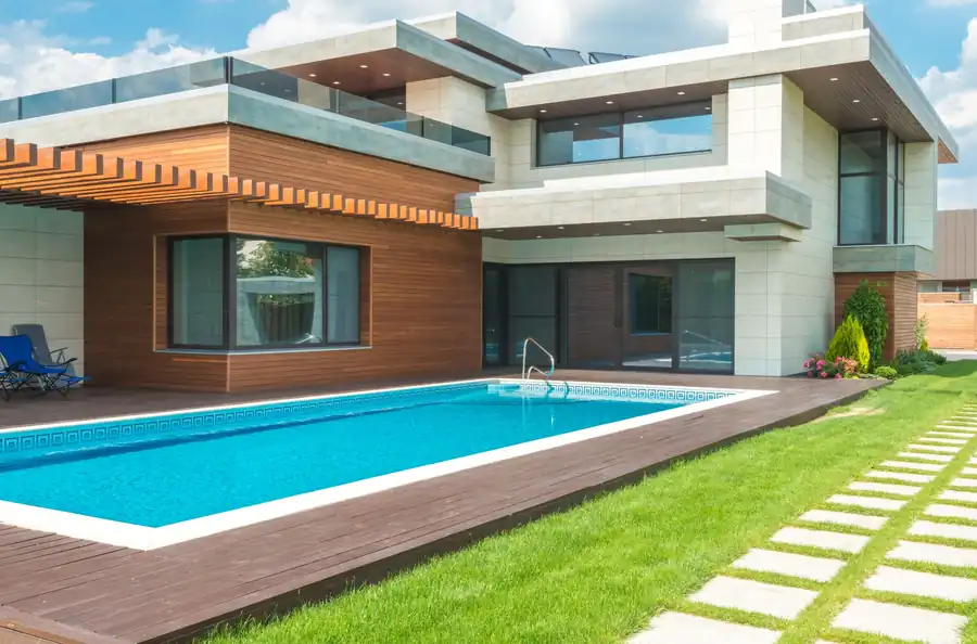 Rectangular pool set into a lawn beside a modern house
