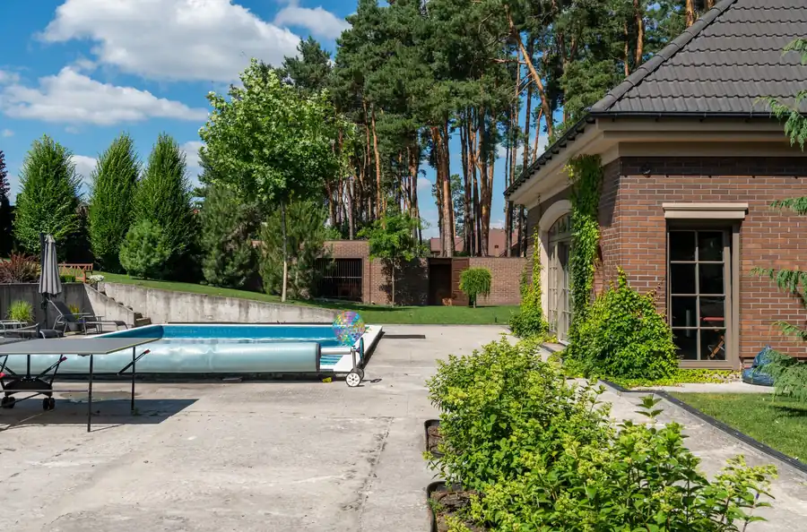 Suburban home with a fenced rectangular pool and decking
